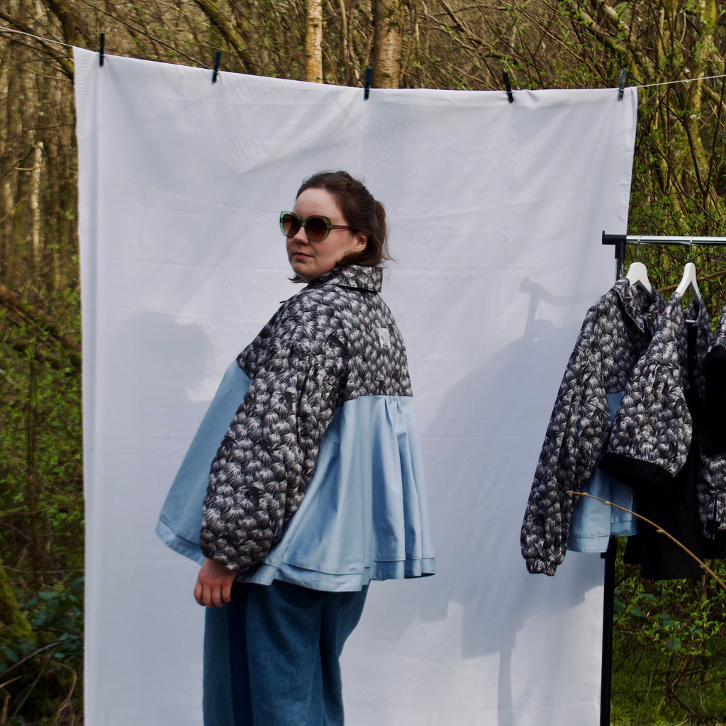 lightweight sustainable bomber jacket for women with black floral and animal print with blue contrast. long sleeves, elastic cuffs, collar, zip closure and breast pocket, oversized fit. casual spring summer jacket for women