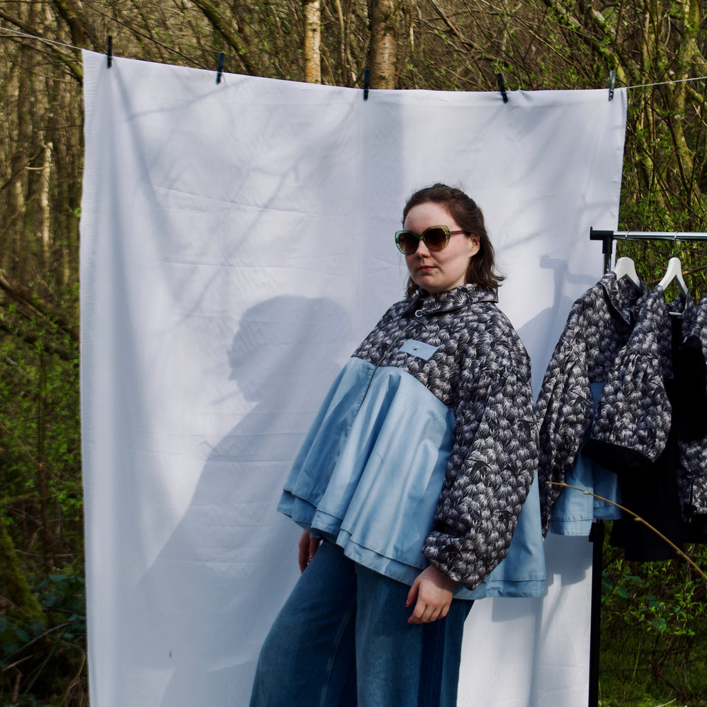 lightweight sustainable bomber jacket for women with black floral and animal print with blue contrast. long sleeves, elastic cuffs, collar, zip closure and breast pocket, oversized fit. casual spring summer jacket for women