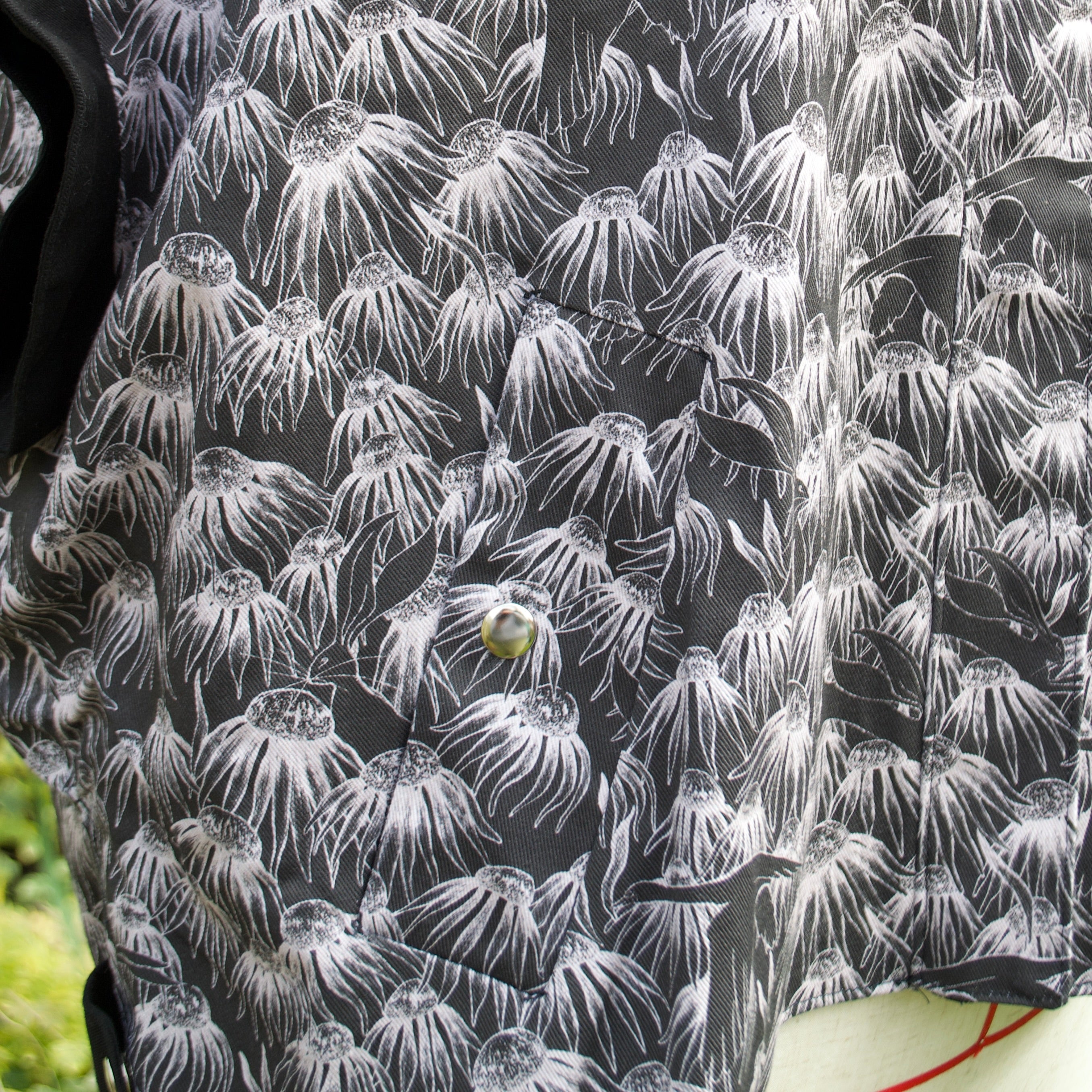 100% cotton lightweight gilet with concealed pockets and side openings for added movement and inclusive sizing. hidden zip closure, whimsical black and white print with flowers, swans and hares perfect for spring summer