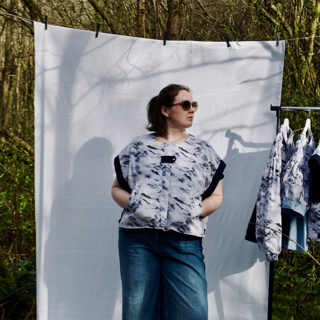 handmade, lightweight gilet vest for spring summer, light blues and white cute cloud fabric with navy sleeve trims, oversized casual fit, hidden zip closure, concealed pockets with popper fastening, side openings for inclusive sizing