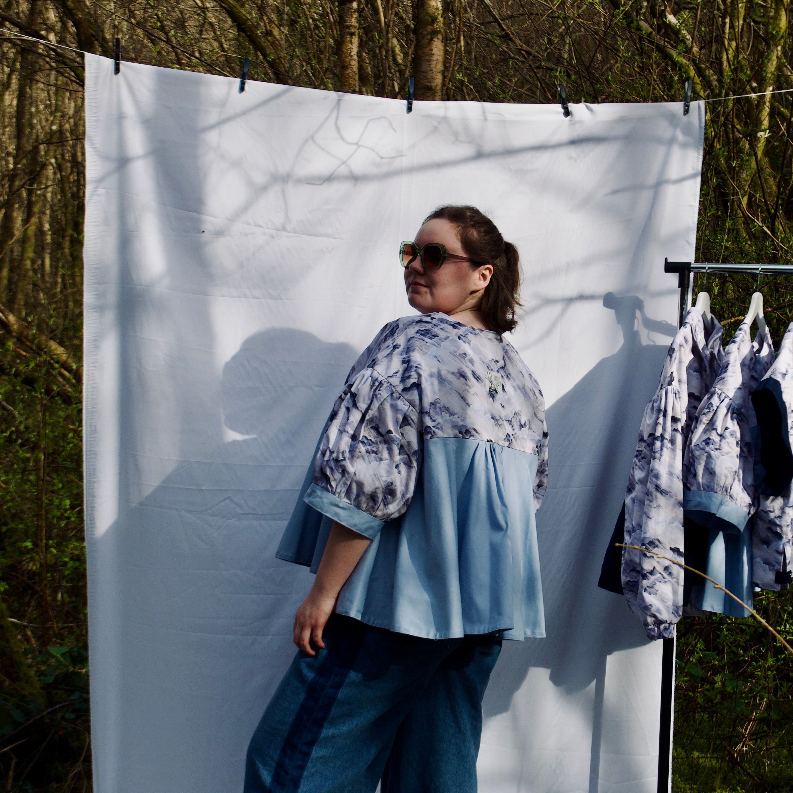lightweight sustainable jacket with short sleeves for women with blues and cream cloud print and light blue contrast. puff sleeves, hidden zip closure and pockets with snap fastening, oversized fit, unique gathered ruffle silhouette. casual spring summer jacket for women 