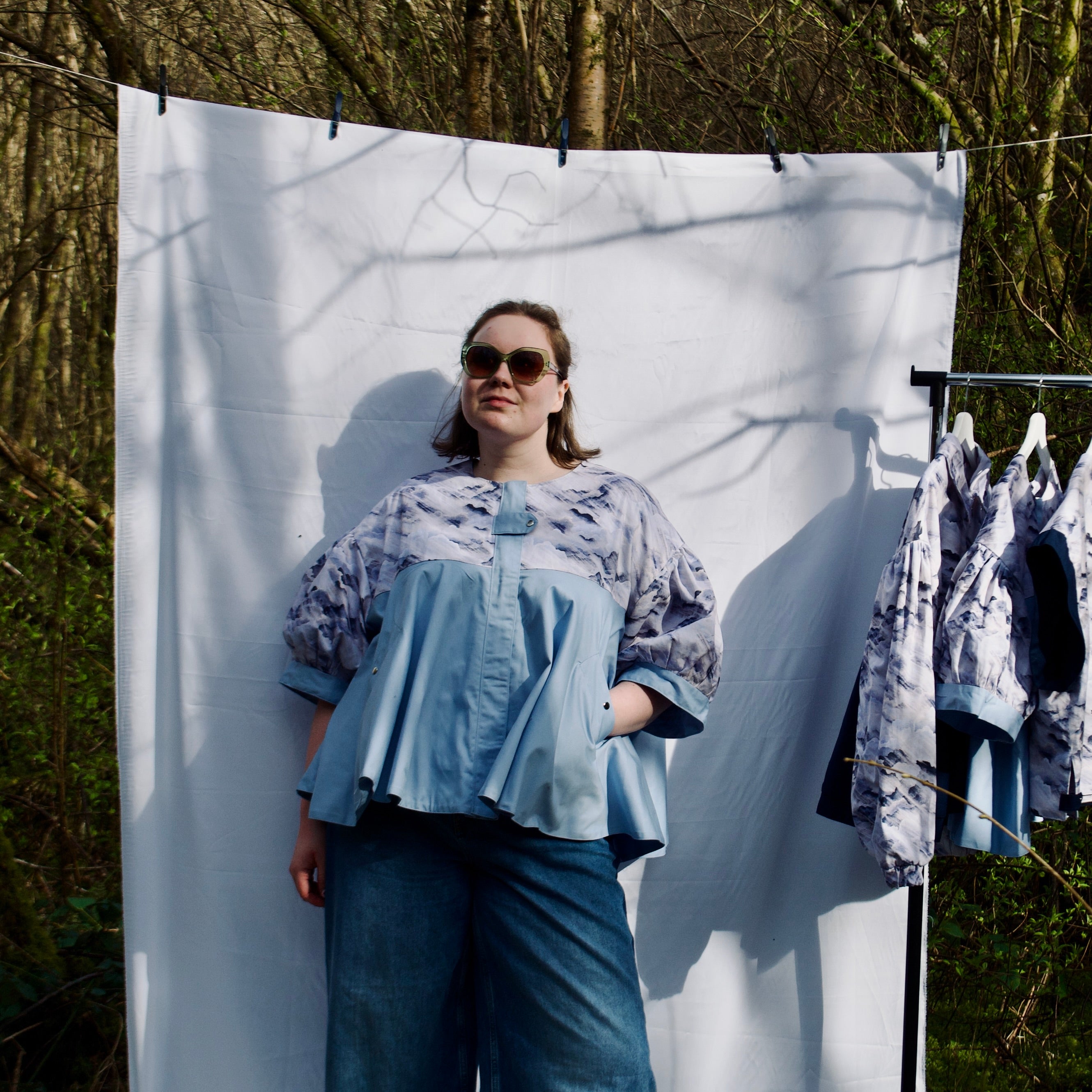 lightweight sustainable jacket with short sleeves for women with blues and cream cloud print and light blue contrast. puff sleeves, hidden zip closure and pockets with snap fastening, oversized fit. casual spring summer jacket for women