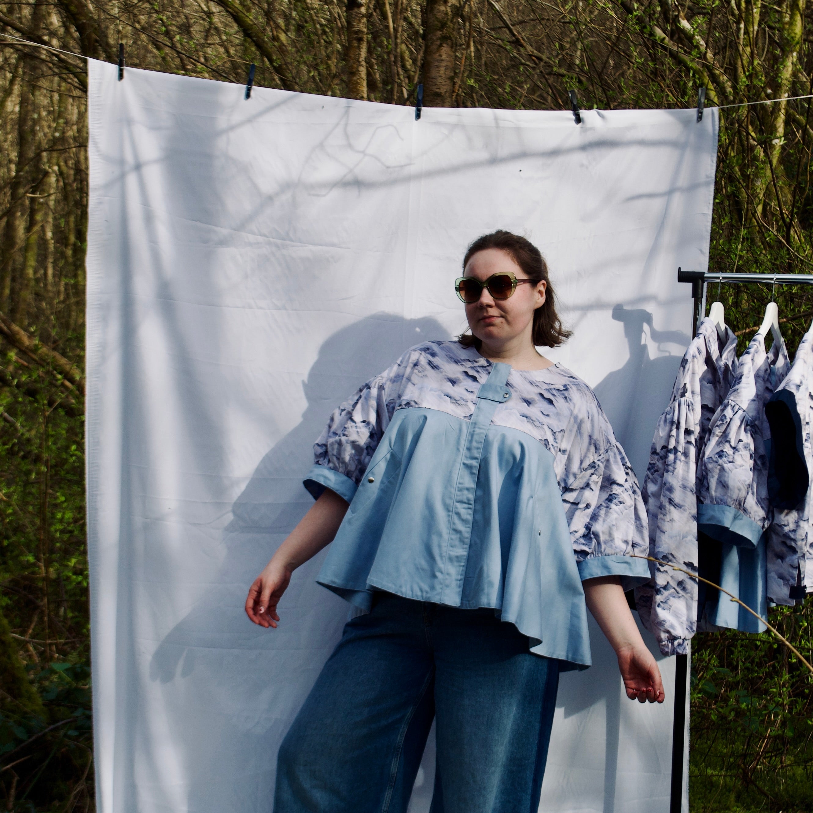 lightweight sustainable jacket with short sleeves for women with blue and cream cloud print and sky-blue contrast. puff sleeves, hidden zip closure and pockets with snap fastening, oversized fit. casual spring summer jacket for women